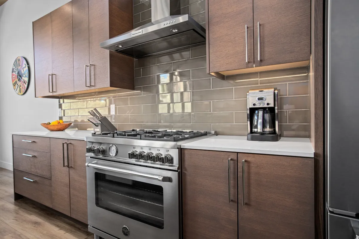 A gourmet kitchen with stainless steel oven, dark wood cabinetry, and a well-appointed countertop, inviting guests to cook, entertain, or gather for memorable meals.
